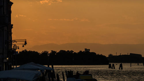 Silhouette sailboats in sea against sky during sunset