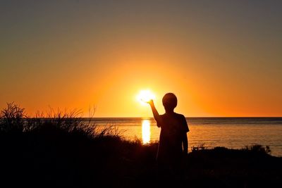 Silhouette of people at beach during sunset