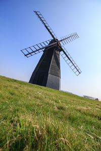 Traditional windmill on field against sky