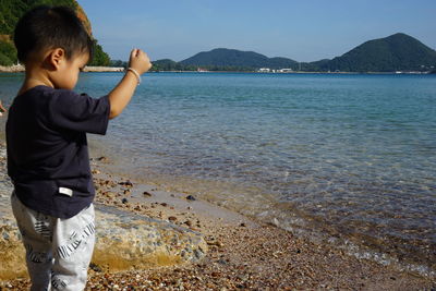 Full length of boy on beach against sky