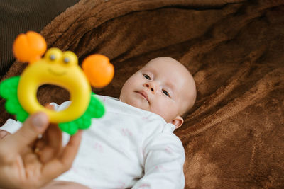 First rattle toy for baby. rattles and teethers, teething toys. cute newborn baby girl looking at