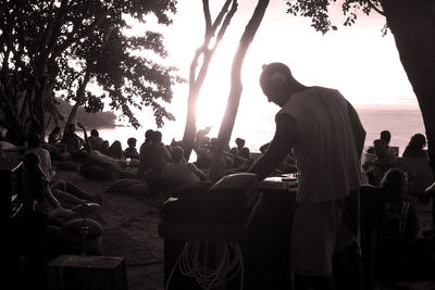 Silhouette of people sitting against sky