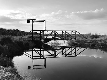 Lifeguard hut by lake against sky