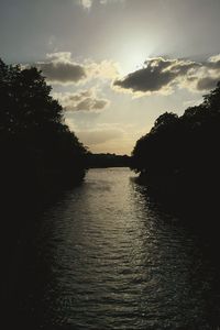 Scenic view of river against cloudy sky