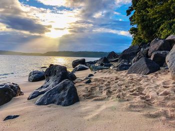 Scenic view of rocks on beach against sky