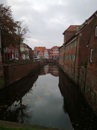 Canal amidst buildings in town against sky