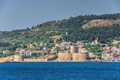 Townscape by sea against clear sky