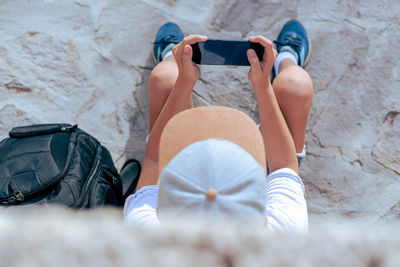 Low section of woman relaxing on bed
