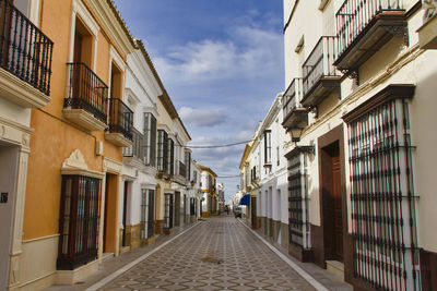 Narrow street amidst buildings against sky