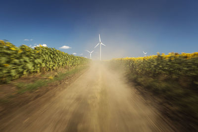 Panoramic view of road amidst field against sky