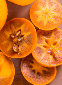 Persimmon cut into halves on a plate on a wooden table,copy space,closeup