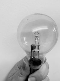 Close-up of hand holding light bulb