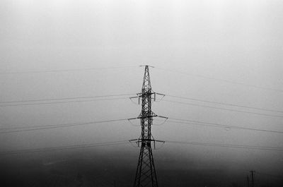 Low angle view of electricity pylon against clear sky