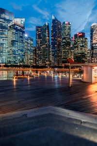 Illuminated modern buildings in city against sky