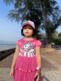 Portrait of cute girl standing against sky