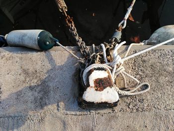 High angle view of chains and ropes tied to bollard on pier