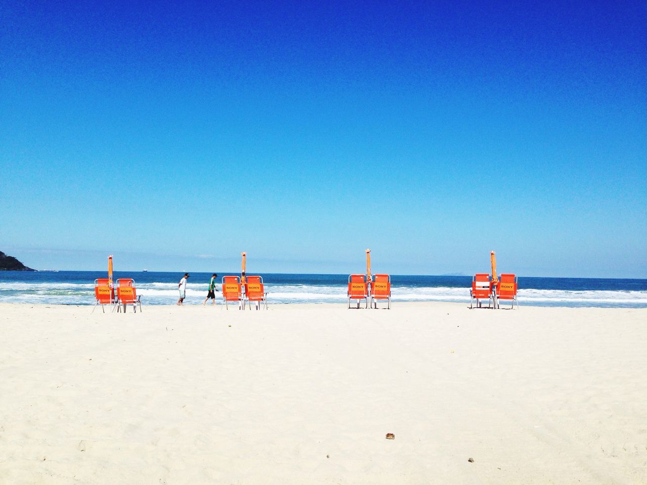 beach, sea, sand, water, horizon over water, shore, clear sky, blue, copy space, tranquility, tranquil scene, nautical vessel, scenics, beauty in nature, nature, boat, day, vacations, incidental people, transportation