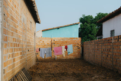 Clothes drying on wall by building against sky