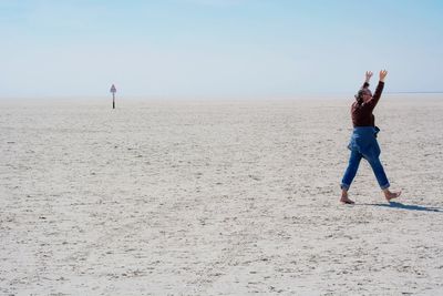 Man walking on sand at beach