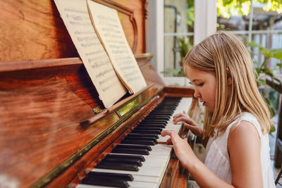 Cute girl playing piano at home