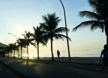 Silhouette palm trees on promenade against sky at sao conrado