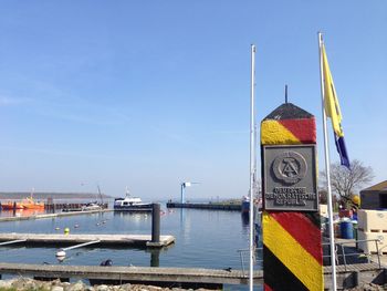 Sailboats in harbor against sky