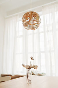 Close-up of electric lamp hanging on table at home