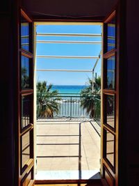 Swimming pool against sky seen through window