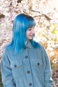 Young woman standing against trees