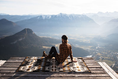 Rear view of man looking at mountain against sky