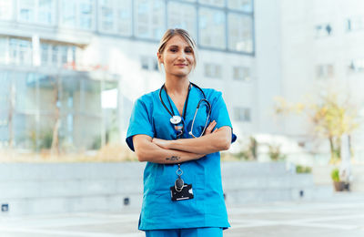 Portrait of young woman standing in city