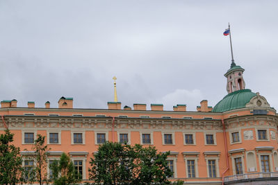 Low angle view of buildings against cloudy sky