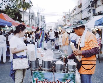 Group of people at market stall in city