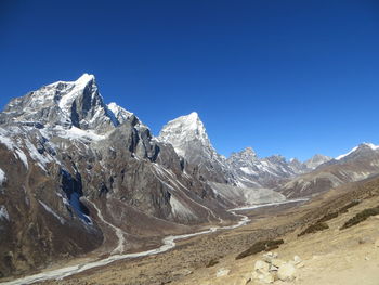 Scenic view of mountains against clear blue sky