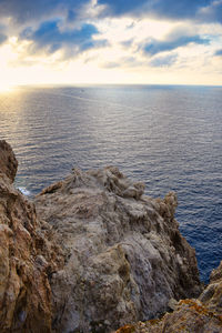 Scenic view of rocks in sea against sky