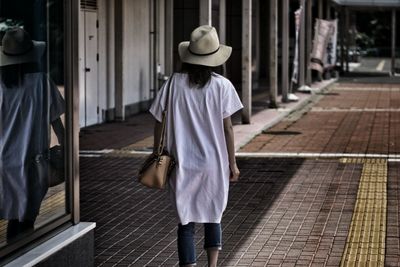 Rear view of man standing in front of building