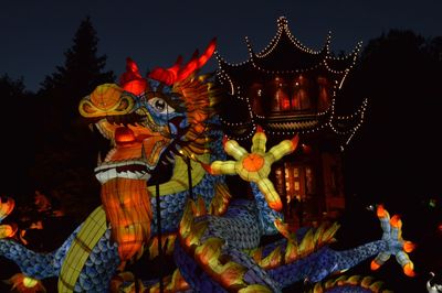 Low angle view of illuminated statue against sky at night