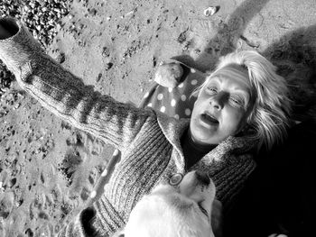 High angle view of woman with dog lying at beach