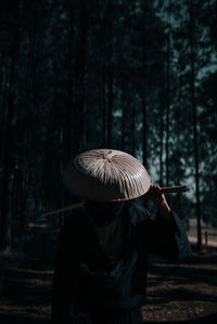 Woman standing by tree in forest