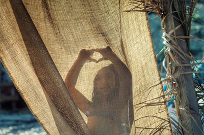 Close-up girl behind curtain on beach