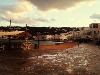 Buildings in town against cloudy sky