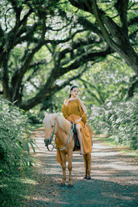 Rear view of woman standing in forest