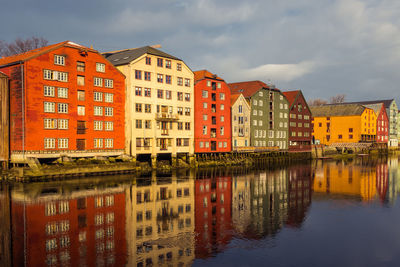 Reflection of buildings on river against sky