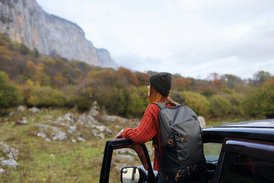 Rear view of man looking at mountain against sky