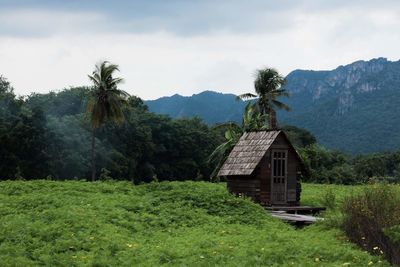 Cottage by land against mountain