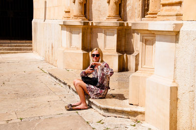 Full length of woman sitting outdoors