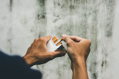 Close up man hand holding peel it off cigarette pack prepare smoking a cigarette. packing line up.