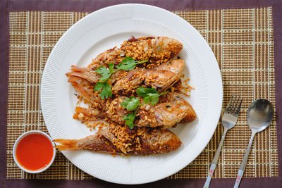 Directly above shot of fried fish thai food in plate on table