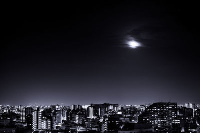 Illuminated buildings in city against sky at night