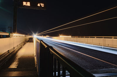 Illuminated bridge against sky at night